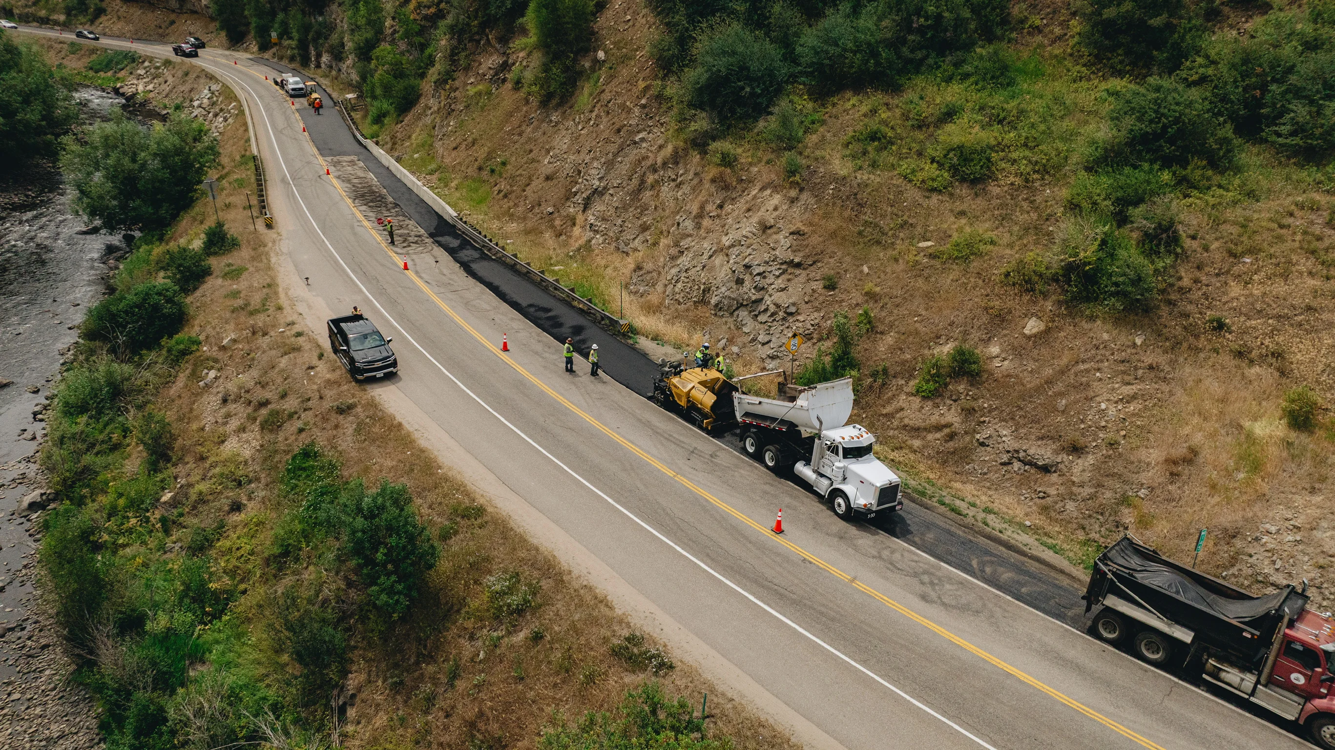 MD Asphalt crew and paving equipment installing a new mountain-road lane
